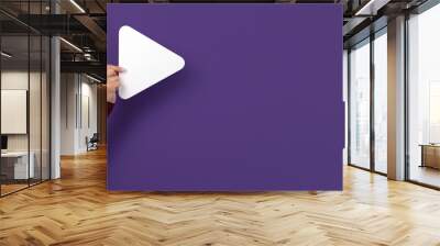 Play button in hand over purple background, panoramic layout Wall mural