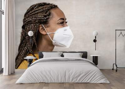 African woman with braids wearing face medical mask - Young girl using facemask for preventing and stop corona virus spread - Healthcare medical and youth millennial people concept Wall mural