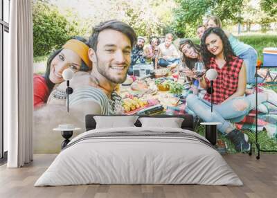 Group of  friends taking a selfie in the park  on a sunny day - Happy people having a picnic eating and drinking wine while taking photo with a mobile phone - Friendship, lifestyle, recreation concept Wall mural