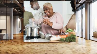 Happy black family having fun cooking together in modern kitchen - Food and parents unity concept Wall mural