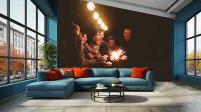 Happy family celebrating holidays with sparklers fireworks at night dinner party - Group of people with different ages and ethnicity having fun together Wall mural