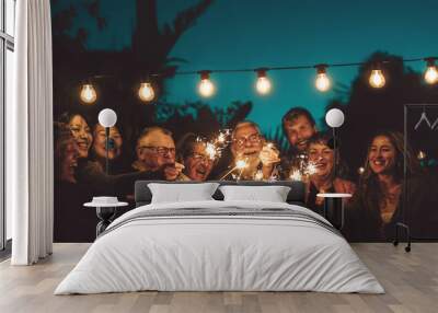 Happy family celebrating with sparkler at night party outdoor - Group of people with different ages and ethnicity having fun together outside - Friendship, eve and celebration concept Wall mural