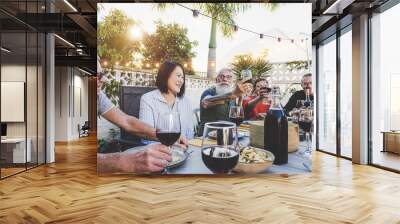 Happy family eating and drinking red wine at dinner barbecue party outdoor - Retired friends having fun dining together at restaurant - Concept of food and drink with elderly weekend lifestyle people Wall mural