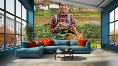 Happy female farmer working in countryside holding fresh vegetables basket - Farm people lifestyle concept Wall mural