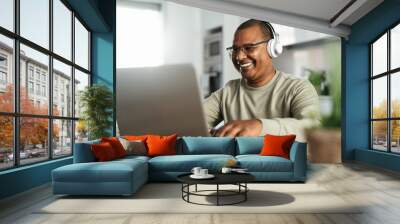 Happy mature Latin man using laptop at home - Technology and smart working concept Wall mural