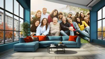 Happy multigenerational people having fun sitting on grass in a public park Wall mural