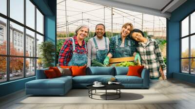 Happy multiracial women farmers working inside greenhouse - Farm people cooperative concept Wall mural