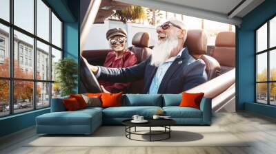 Happy senior couple having fun on new convertible car - Mature people enjoying time together during road trip vacation - Elderly lifestyle and travel transportation concept Wall mural