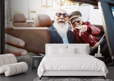 Happy senior couple taking selfie on new convertible car - Mature people having fun in cabriolet together during road trip vacation - Elderly lifestyle and travel transportation concept Wall mural