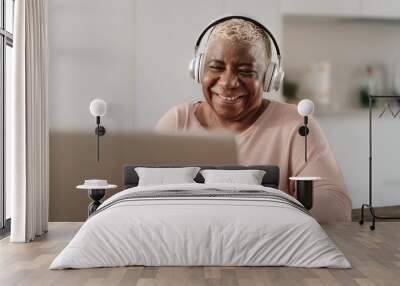 Happy senior woman having fun using a laptop in her house - Technology and smart working concept Wall mural