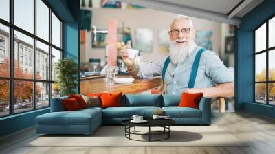 Senior bearded man drinking coffee sitting bar counter - Happy mature male having fun enjoying time outdoor - Elderly people lifestyle concept Wall mural