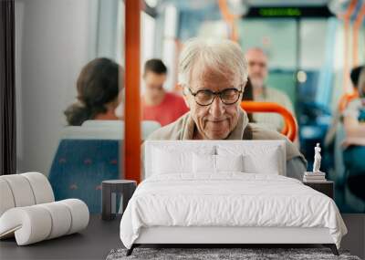 Senior man reading book while traveling with bus Wall mural