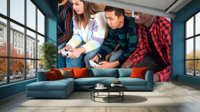 Young multiracial teenagers playing online video game console at home - Youth people addicted to new technology gaming entertainment Wall mural