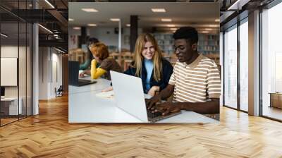 Young people studying together in university library - School education concept Wall mural