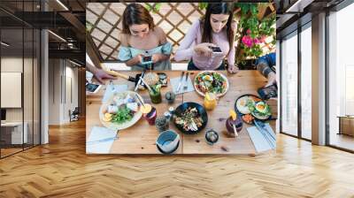 Young people taking food pictures with mobile smartphone to share on social media while having healthy meal in bar restaurant - Youth generation z and technology concept Wall mural