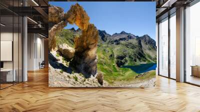 The famous Arc de Tortisse, natural arch in the national park of Mercantour (France) with the upper lake of Vens on the background Wall mural