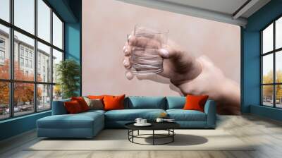 Trembling hand holding glass with alcohol drink Wall mural