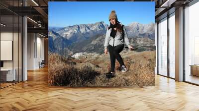 a young woman makes trekking on a mountain in a winter day Wall mural