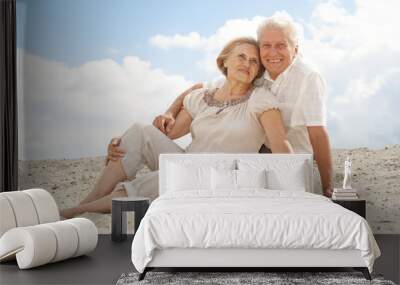 Charming elderly people enjoy the sea breeze Wall mural