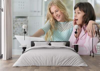 Close up portrait of two girls using laptop Wall mural