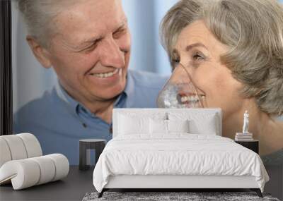 Elderly couple with inhaler Wall mural