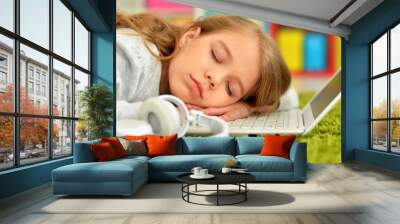 Emotional cute girl sleeping near laptop Wall mural