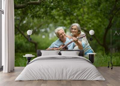 Mature couple with guitar   in park Wall mural