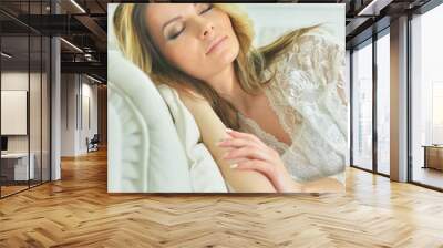 Portrait of beautiful young woman sleeping on sofa Wall mural