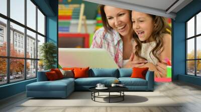 portrait of mother and daughter using laptop Wall mural