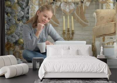 Teenage girl with laptop on floor on Christmas Wall mural