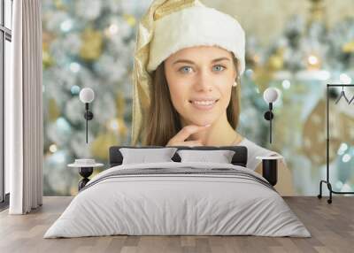 Young woman in Christmas hat posing at home Wall mural