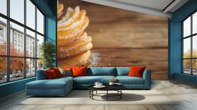 A close-up shot of golden, crispy churros on a rustic wooden table, with an empty space to the side for text.Churros.Traditional Mexican and Spanish dessert.Street food.Fresh sugar churros. Wall mural