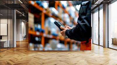 A worker in a warehouse scans inventory using a handheld scanner Wall mural