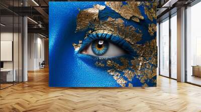 Artistic make-up and body art theme: portrait of a beautiful young girl model with blue make-up all over the body with gold foil for make-up Wall mural