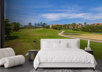 Beautiful landscape view of golf course with green grass in background of hotel with lake. Aruba. Wall mural