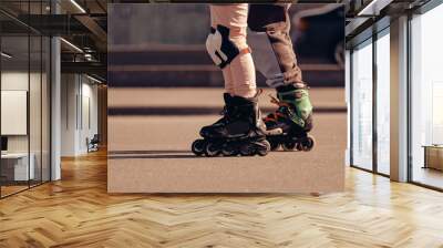 Two roller skaters ride on roller skates next to the road. Wall mural