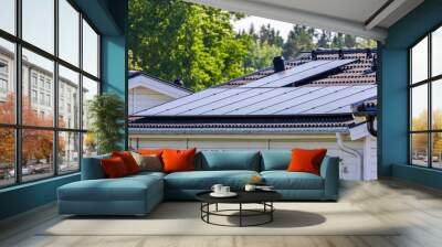 Close-up perspective of a villa roof integrating advanced solar panel technology within a village setting. Wall mural