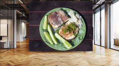 Close up view of plate with two sandwiches, chees and cucumber on wooden background. Healthy eating concept.  Wall mural