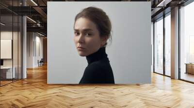 Dramatic portrait of a young beautiful girl with freckles in a black turtleneck on white background in studio Wall mural