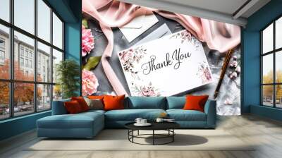 Floral thank you card surrounded by pink flowers and ribbon on gray surface. Gold pen nearby for heartfelt message of gratitude Wall mural