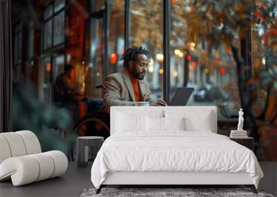 Focused black disabled man in wheelchair working with documents, using laptop at home office. Handicapped Afro man sitting at desk with computer, checking financial reports.  Wall mural