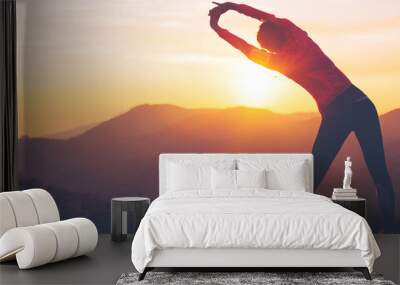 Athletic girl doing stretching after the evening jog. Sport tight clothes. Wall mural