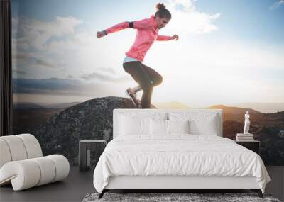 Athletic girl running in the mountains at sunset against the backdrop of a beautiful landscape. Sport tight clothes. Intentional motion blur. Wall mural