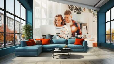 Couple in love. Happy family watching TV series using laptop and sitting on the couch Wall mural