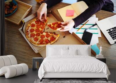 Family couple have pizza break for lunch together on the working table Wall mural