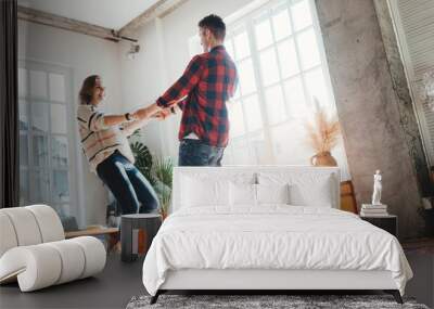 Happy couple domestic life situation. Wife and husband dancing and hugging together in big loft room Wall mural