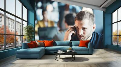 Man employee sitting at the office talking on the phone Wall mural