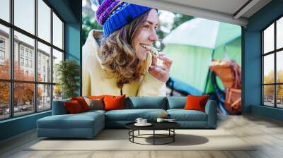 Pretty young woman tourist eating snack and camping in the wild Wall mural