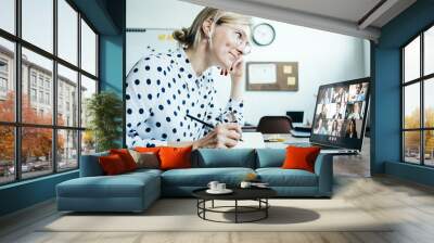 Smiling woman with googles has video call conference with her remote team. Laptop with camera teamwork Wall mural