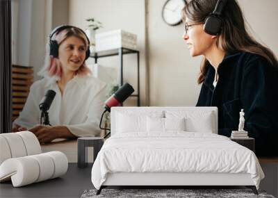 Two woman hosts in local broadcat studio recording audio podcast, interesting conversation Wall mural